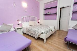 um quarto com 2 camas e paredes roxas em Stella Marina em Camogli