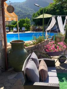 eine Terrasse mit einem Sofa und einem Pool in der Unterkunft La Beverita in Ventimiglia