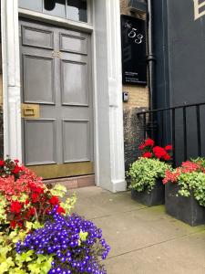 een deur van een gebouw met bloemen ervoor bij No. 53 Frederick Street in Edinburgh
