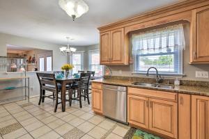 a kitchen with wooden cabinets and a table with chairs at Virginia Beach Family House Less Than 1 Mi to Golf Club! in Virginia Beach