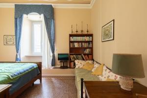 1 dormitorio con cama, sofá y estante para libros en Attico Luce B&B, en Osimo