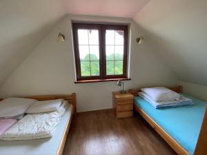 2 camas individuales en una habitación con ventana en Ignacówka, en Kobyla Góra