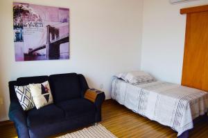sala de estar con sofá y cama en Apartamento novo, completo e com ótima localização, en Pirassununga