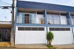 un edificio azul y blanco con dos puertas blancas de garaje en Apartamento novo, completo e com ótima localização, en Pirassununga