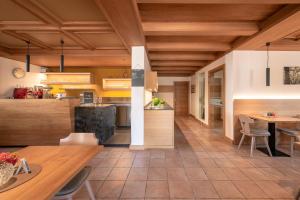 a kitchen with wooden ceilings and a table and chairs at Pension Etschblick B&B in Frangarto