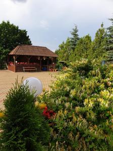 a garden with a gazebo in the background with flowers at Pensiunea Confort in Suceava