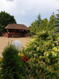 ein Garten mit einem Pavillon im Hintergrund mit Blumen in der Unterkunft Pensiunea Confort in Suceava