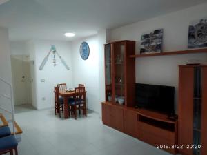 uma sala de estar com uma televisão e uma sala de jantar em PEP'S Family House em Empuriabrava