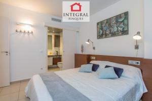 um quarto com uma cama grande e almofadas azuis em Palamós BeachFront Apartment em Palamós