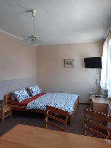 ペツ・ポト・スニェシュコウにあるUbytování Kocováのベッドルーム(ベッド1台、テーブル、テレビ付)
