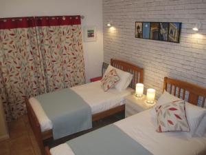 een slaapkamer met twee bedden en twee kaarsen erin bij Casa Carmela in Burgau +22 foto's