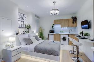 um quarto branco com uma cama e uma cozinha em La Maria - Dijon Centre em Dijon