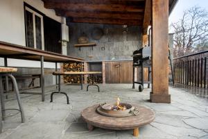een vuurplaats op een patio met een grill bij Baite Etna Bottino in Milo
