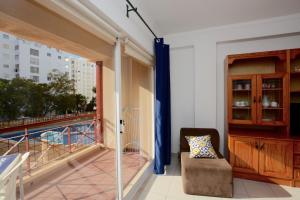 een kamer met een balkon met een stoel en een raam bij Edificio Fragata A in Armação de Pêra