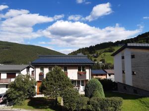 una casa con techo azul con una colina al fondo en Ubytování Kocová en Pec pod Sněžkou