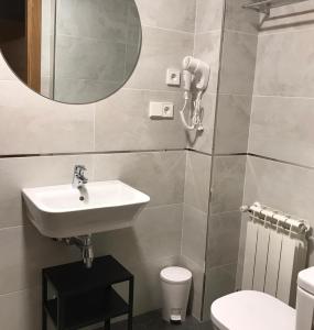 uma casa de banho com um lavatório, um WC e um espelho. em Hotel Baltico 2 estrellas em Luarca