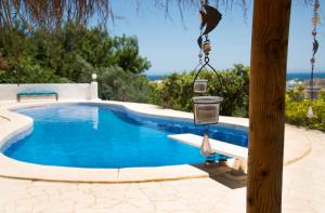 Una pequeña piscina con un comedero para pájaros colgado de un poste. en Villa Samar Altea Grupo Terra de Mar, alojamientos con encanto, en Altea