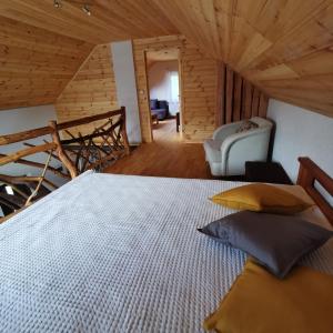 1 dormitorio con 1 cama y 1 silla en una habitación en Burziņi, en Kuldīga