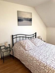 a bedroom with a bed and a picture on the wall at chez Suzanne in Chooz