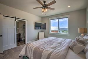 Schlafzimmer mit einem Bett, einem Deckenventilator und einem Fenster in der Unterkunft Lake-View Escape with Private Beach Resort Access! in Garden City