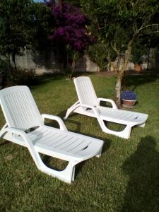 two white lawn chairs sitting in the grass at Mamena in Paestum