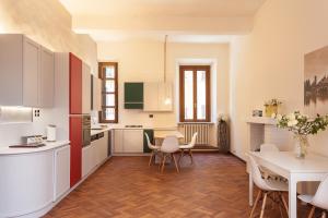 a kitchen with white cabinets and a table and chairs at Casa Iolanda in Mantova