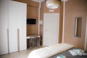 een slaapkamer met een bed, een bureau en een tafel bij La Corte di BisMary B&B in Salerno