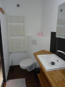 a white bathroom with a toilet and a sink at Domaine de l'Etre in Saint-Pierre-du-Regard
