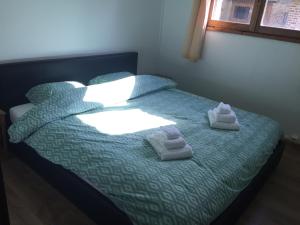 1 dormitorio con 1 cama con toallas en De Skure en Harelbeke