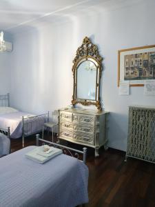 a bedroom with a dresser with a mirror on it at Around The Corner Colosseo B&B in Rome