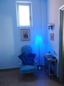 a blue room with a blue chair and a lamp at Around The Corner Colosseo B&B in Rome