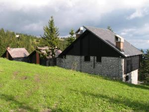 een oud stenen huis op een grasheuvel bij Apartmaji Snežinka Kope in Slovenj Gradec