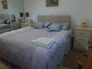 a bedroom with a purple bed with towels on it at Lady lane stables in Denby