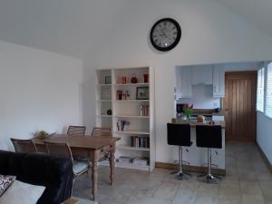 ein Wohnzimmer mit einem Tisch und einer Uhr an der Wand in der Unterkunft Lady lane stables in Denby