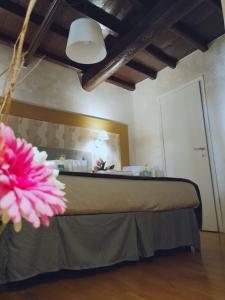 1 dormitorio con 1 cama con una flor rosa en Dulcis In Pantheon, en Roma