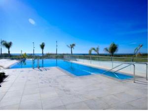 a swimming pool with palm trees and the ocean in the background at Buddha house in Torrox Costa