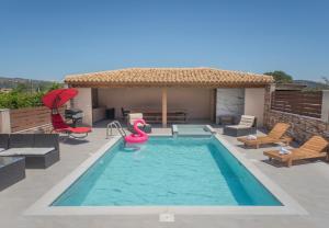 a swimming pool with a water slide in front of a house at M & S Villa - 3 bedroom villa with heated pool in Pastida