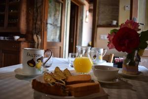 a table with a plate of bread and a cup of orange juice at B&B Il Fortino in Talla
