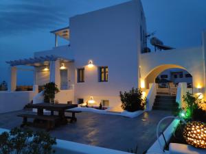 a villa with a table in the yard at night at Santoxenia luxury villa in Kamari