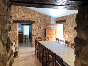 a stone room with a large stone table and chairs at Casa Rural La Calzada in El Payo