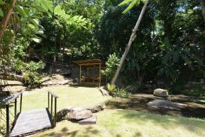 a garden with a gazebo and a bench at Pousada Sítio Olho D'Água in Bombinhas