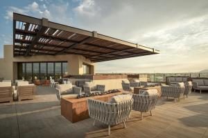 a patio with chairs and tables on a roof at Hotel Chaco in Albuquerque