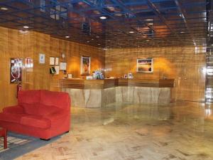 vestíbulo con sofá rojo y bar en Hotel Ébora by Vivere Stays, en Talavera de la Reina