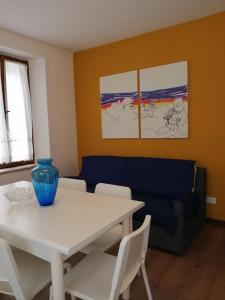 uma sala de jantar com uma mesa e um sofá azul em Appartamento al sole em Pieve di Cadore