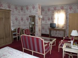 a bedroom with pink wallpaper and chairs and a table at Hotel Ébora by Vivere Stays in Talavera de la Reina