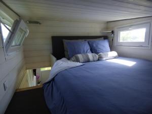 - un lit dans une petite maison avec fenêtre dans l'établissement La tiny des 3 Pics, à Bartrés