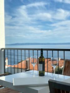 a bottle of wine sitting on a table with two wine glasses at Guest House Stipe in Brela