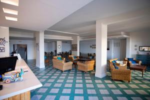 una sala de estar con sofás, mesas y sillas en Hotel Baia Di Puolo en Massa Lubrense