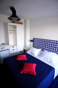 マッサ・ルブレンセにあるHotel Baia Di Puoloのベッドルーム1室(赤い枕2つ付)
