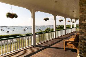 a porch with a view of the water with boats at The Sullivan House in New Shoreham